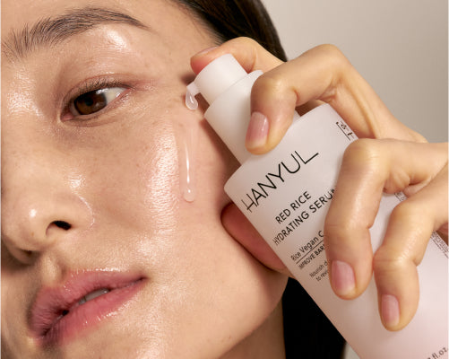 Woman applying RED RICE HYDRATING SERUM to face