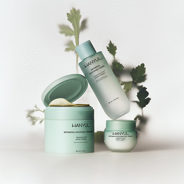 HANYUL Artemisia soothing toner, cream, and toner pads displayed with mugwort leaves.
