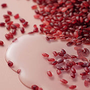 Close-up of red rice grains with watery essence texture.