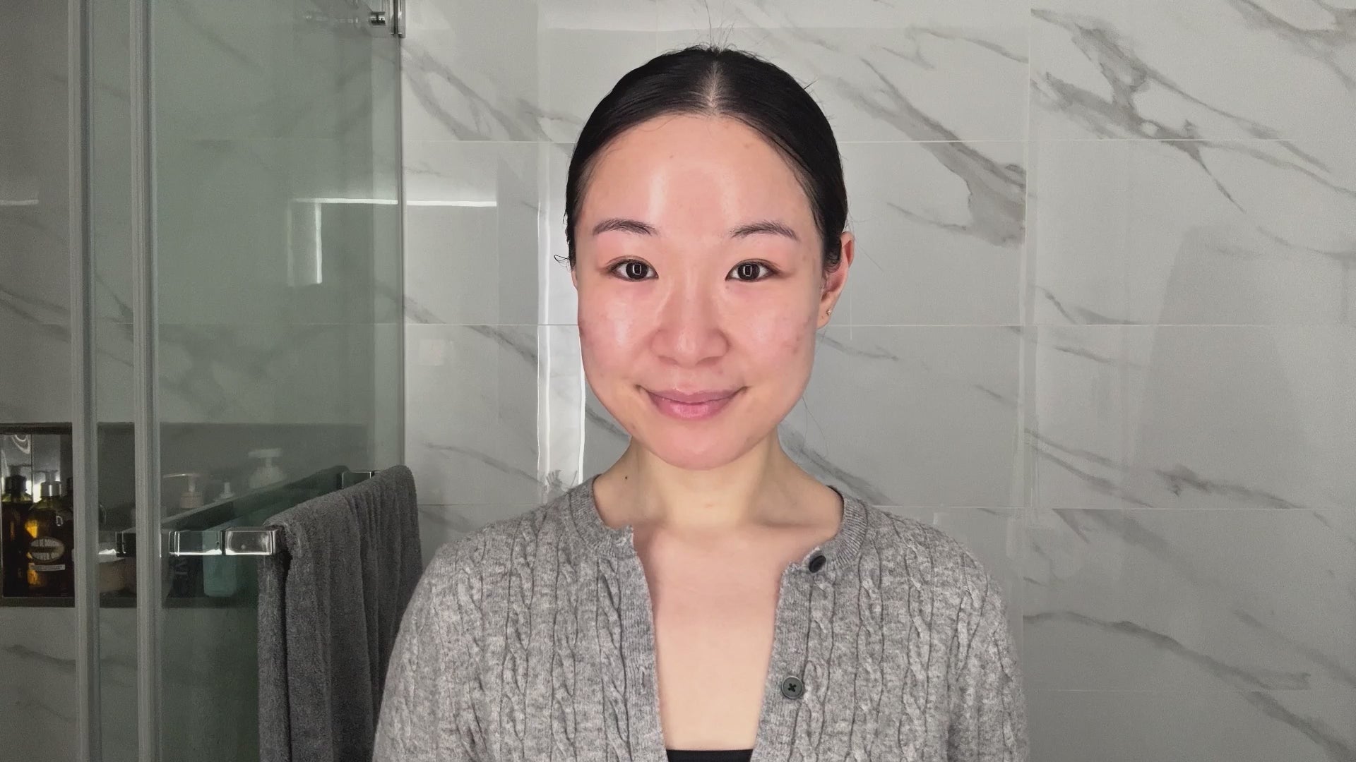 Skincare routine scene with a smiling woman in the bathroom.