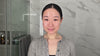 Skincare routine scene with a smiling woman in the bathroom.
